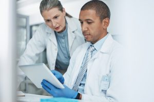 Scientist woman, tablet or teamwork in science laboratory for medical research, medicine or collaboration development. Mature mentor, man and technology for DNA healthcare help in genetic engineering