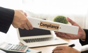 Handing a compliance handbook to a manager
