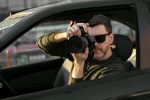 Man private detective taking photos from the car, wearing modern sunglasses