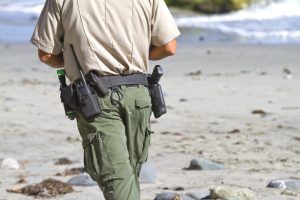 A game warden patrols the shore.