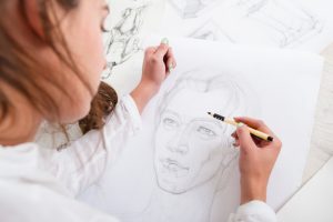 Artist drawing pencil portrait close-up