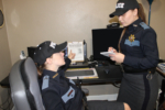 two female police officers in uniform checking things out