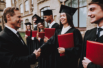 Cheerful. Teacher. Handshake. Students Diplomas. Courtyard. University. Finish Studies. Graduate. Guys. Greet. Group of Young People. Good Mood. Have Fun. Friendship. Knowledge. Cap. Celebration.
