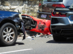 Damaged cars and a scooter involved in a traffic accident on Bondi Road near Bondi Beach. The hazard lights of the Chevrolet Corvette (right) are flashing. The scooter on the ground is a Vespa. The other cars are Subaru and Volkswagen. The road was closed in both directions for several hours. This image was taken near the corner of Dudley Street and Bondi Road on a sunny afternoon on 26 November 2023.