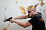 A man appearing to be in pursuit with semi-automatic fire arm in his hands.