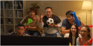 a moment of friends watching a soccer game and celebrating a victory