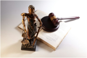 statuette of Lady Justice (Themis) alongside a judge's gavel on a book