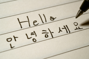 Beginner Korean language learner writing Hello word in Korean characters on a notebook macro shot