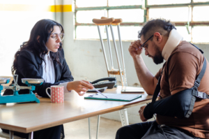 Young female lawyer assist a injured man with legal problem. Man reading document. Compensation for work or car accident. Legal concept. Social Worker.