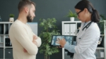 healthcare professional reviewing medical data on a tablet with a patient