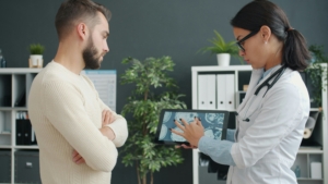healthcare professional reviewing medical data on a tablet with a patient