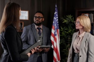 Diverse group of professionals in a formal office setting featuring an American flag and bookshelves
