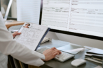 Doctor Reviewing Patient Records and Updating Digital Medical Forms