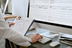 Doctor Reviewing Patient Records and Updating Digital Medical Forms