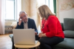 Individuals discussing financial planning topics, such as retirement security and estate planning, in a home office setting