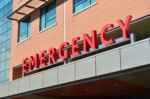 This image shows the exterior of a building with a red sign indicating an emergency department