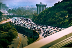 Heavy daytime traffic on the Interstate 405 (San Diego Freeway) looking north through the Sepulveda Pass in Los Angeles, California, with the distinctive cylindrical Hotel Angeleno visible in the background