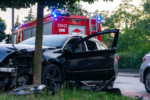 Damaged passenger car after road accident, fire brigade on scene