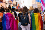 Person wrapped in rainbow flag walking
