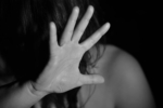 A person holding up a hand in a defensive or shielding gesture
