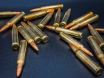 Close-up view of scattered rifle cartridges with brass casings and copper-jacketed full metal jacket (FMJ) bullets